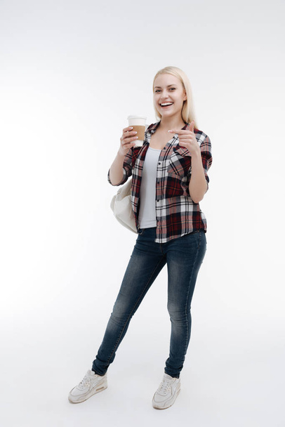 Full length photo of smiling female that pointing at her cup - Foto, afbeelding