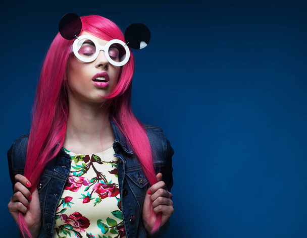 fashion girl with pink hair and big sunglasses over blue  background - Fotografie, Obrázek
