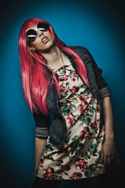 fashion model with pink hair and big sunglasses over blue  background - Photo, image