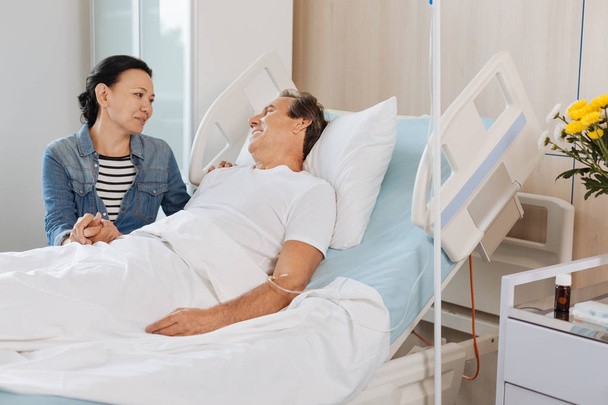 man on hospital bed and looking at wife - Foto, Imagen