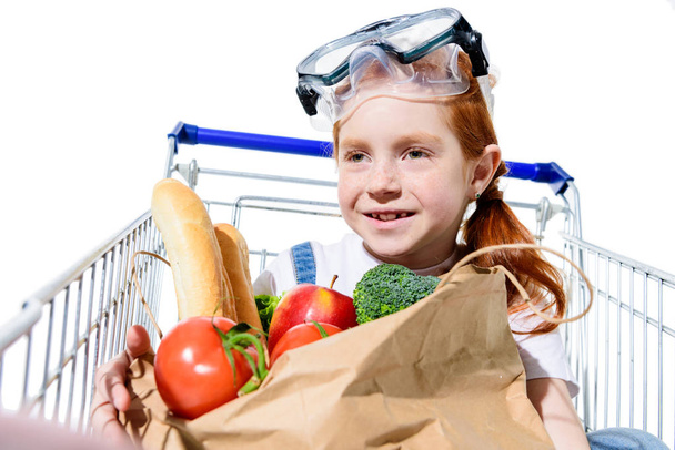 Rotschopfiges Kind mit Einkaufswagen - Foto, Bild