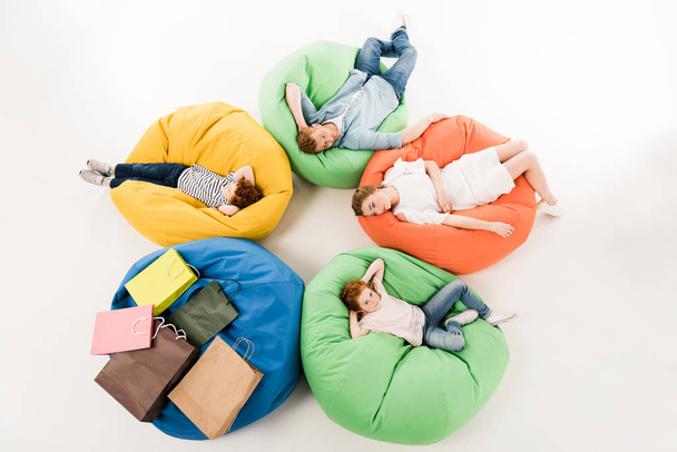family on bean bag chairs after shopping  - Foto, Imagen