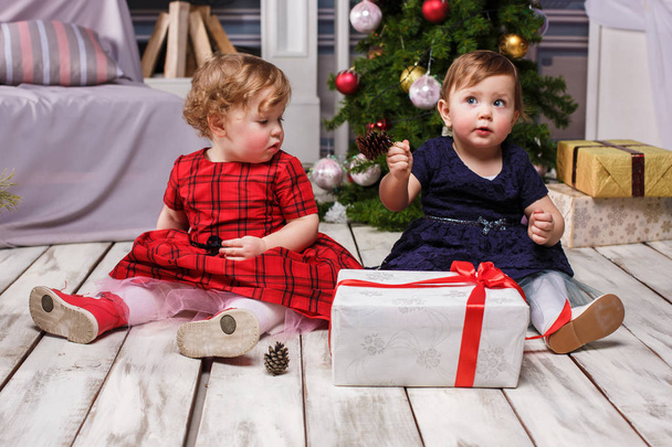 The two little girls sitting at studio with christmas decorations - Fotoğraf, Görsel