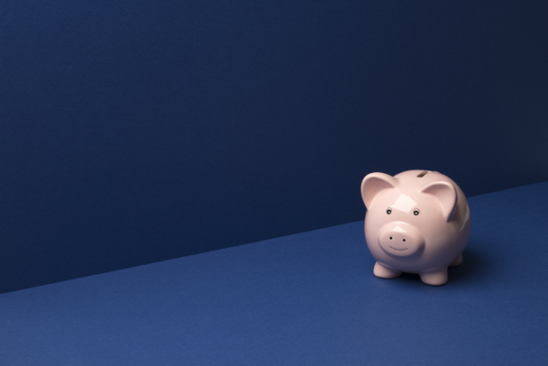 Piggy Coin Bank sobre fundo azul espaço de cópia
 - Foto, Imagem