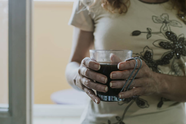 hands of woman with black coffee  - Zdjęcie, obraz