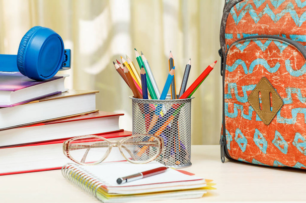 Школьный рюкзак со школьными принадлежностями. Книги, металлическая подставка для ручки
 - Фото, изображение
