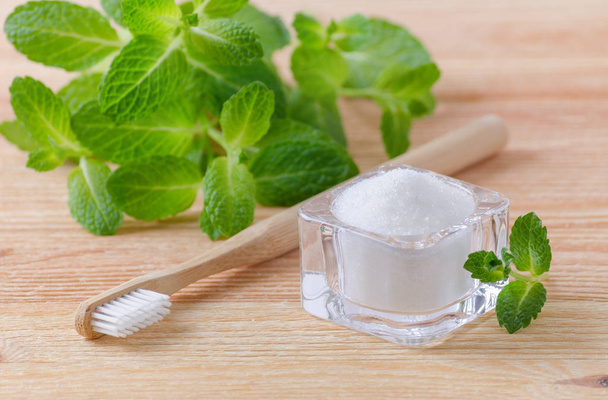 alternative natural toothpaste xylitol, soda, salt, and wood toothbrush, mint on wooden - Photo, Image