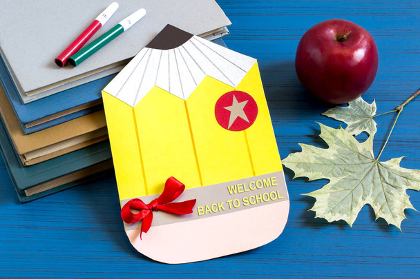Livros, cartão postal caseiro, maçã e folhas de bordo
  - Foto, Imagem