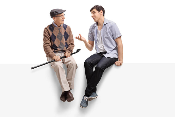 Senior and a man sitting on a panel and talking - 写真・画像