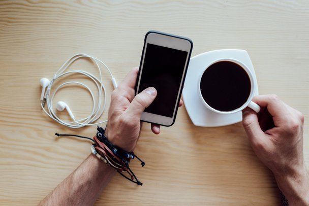 smartphone i filiżankę kawy w rękach - Zdjęcie, obraz