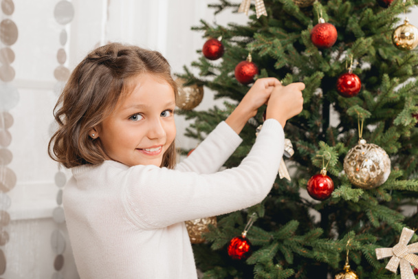 kid decorating christmas tree - Foto, Bild