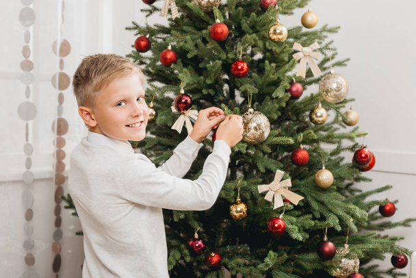 Fiú díszítő karácsonyfa - Fotó, kép