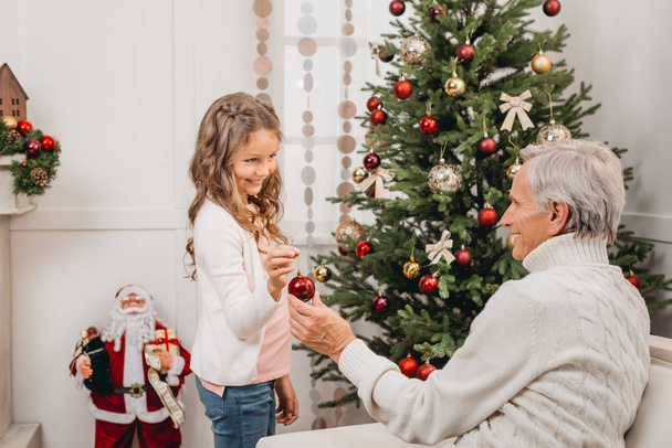 grandfather and granddaughter decorating christmas tree - Zdjęcie, obraz