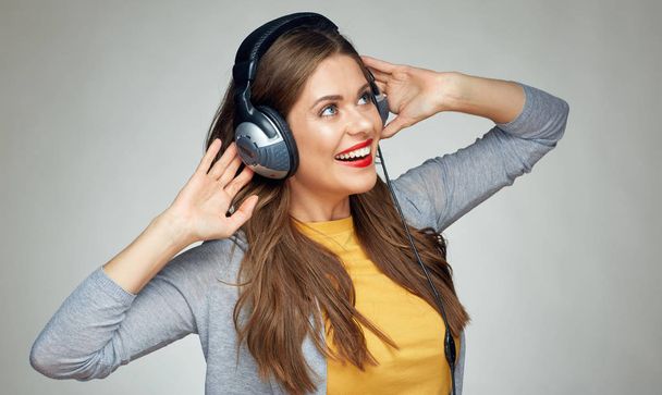 glücklich tanzende Frau mit Kopfhörern auf grauem Hintergrund  - Foto, Bild