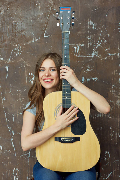 Portrait of smiling woman with acoustic guitar - Photo, image