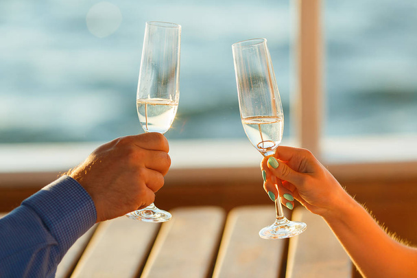 Happy couple drinks champagne on a yacht - Foto, Imagen