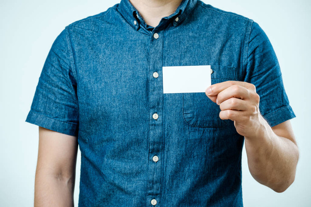 Man showing white blank business card isolated. Focus on card - Zdjęcie, obraz