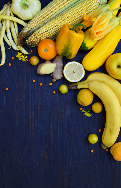 Composition of yellow vegetables and fruits - banana, corn, lemon, plum, apricot, pepper, zucchini, tomato, asparagus beans, ginger. Healthy food. Top view. Flat lay - Fotografie, Obrázek