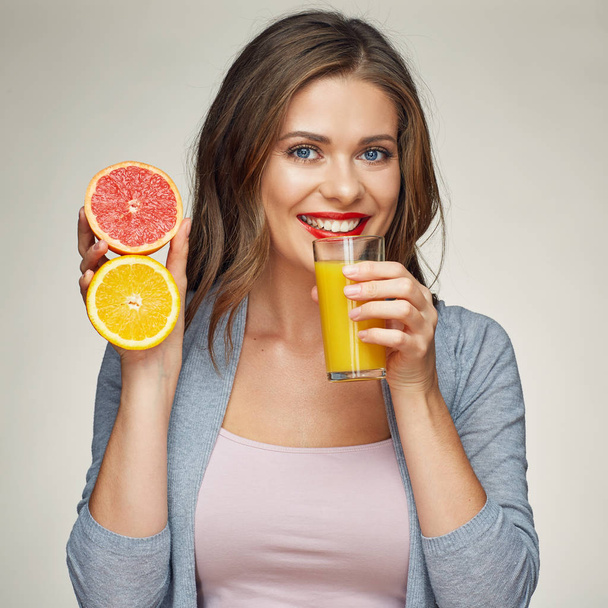 smiling woman holding juice glass with half orange and grapefrui - Zdjęcie, obraz