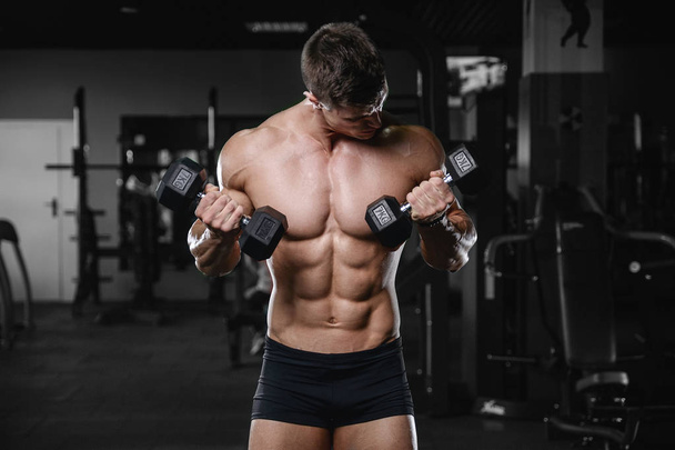Muscular handsome athletic bodybuilder fitness model posing afte - 写真・画像