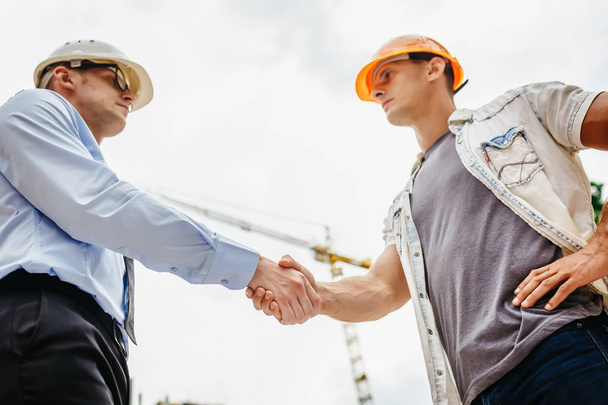 Architecte ingénieur serrant la main de l'autre main sur le chantier de construction. Travail d'équipe, coopération, succès concept de collaboration
 - Photo, image