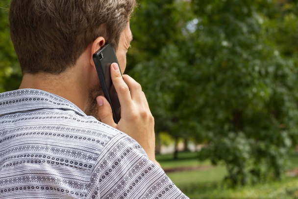 匿名男性が、公園での携帯電話の話 - 写真・画像
