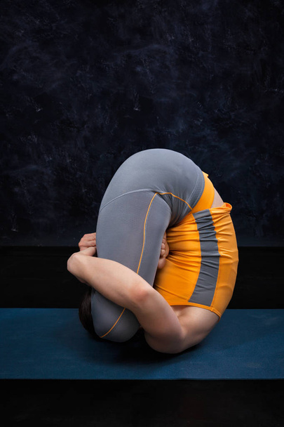 Mujer haciendo Hatha Yoga Ashtanga Vinyasa yoga asana Garbha pindas
 - Foto, imagen