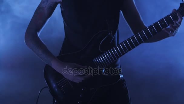 Гитарист-рокер играет на электрогитаре на сцене. Видеорок, панк, хэви-метал группа
. - Кадры, видео