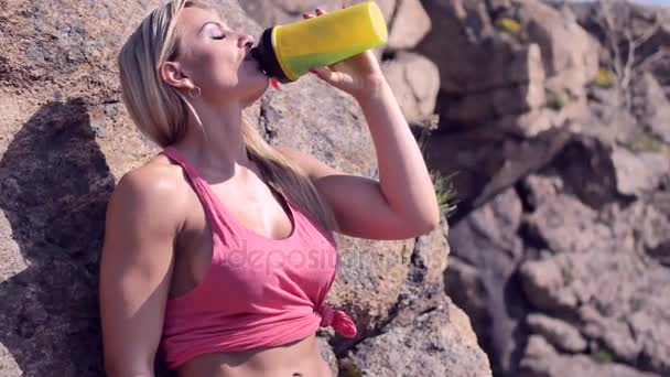 Chica fitness bebe de una botella de deportes
 - Metraje, vídeo