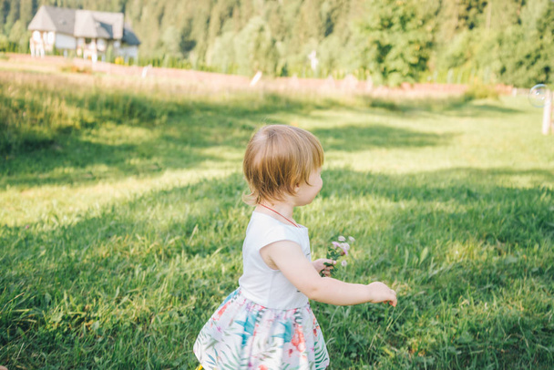 Baby girl spending time outdoor on a summer day. - Foto, afbeelding