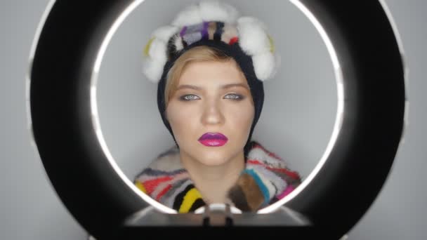 Close-up rosto de modelo de moda em um chapéu com maquiagem profissional em estúdio. Menina com lábios cor de rosa
. - Filmagem, Vídeo