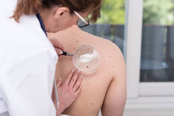 dermatologue examinant la peau d'un patient
 - Photo, image