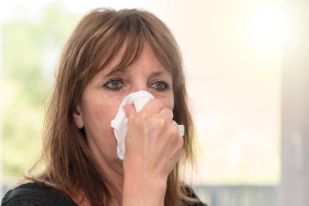 Donna che si soffia il naso, effetto luce
 - Foto, immagini