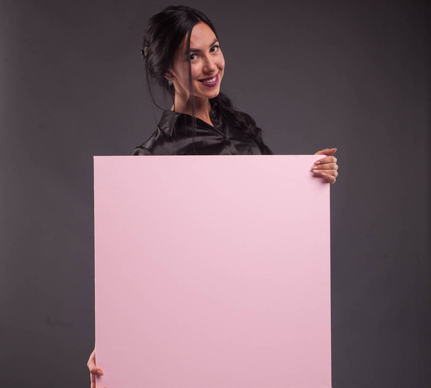 Young happy woman showing presentation, pointing on placard - Foto, Imagen