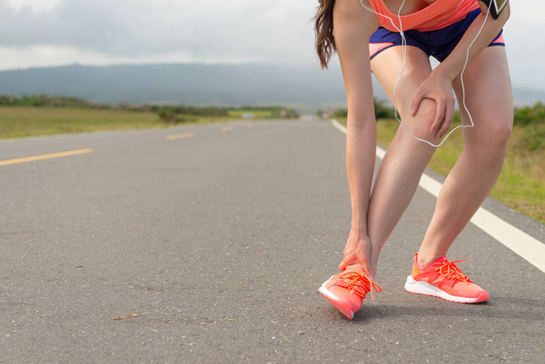 female athlete ankle injury when running on road - Фото, изображение