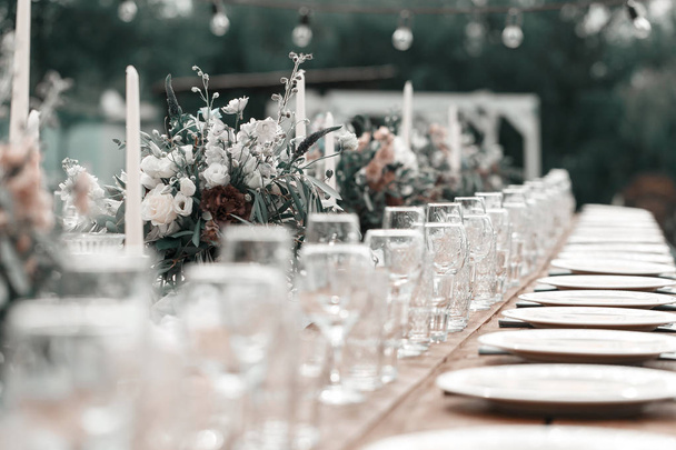Glasses on the festive table setting. Wedding table decor concept. Table setting in classic style, setout. fine art. - 写真・画像
