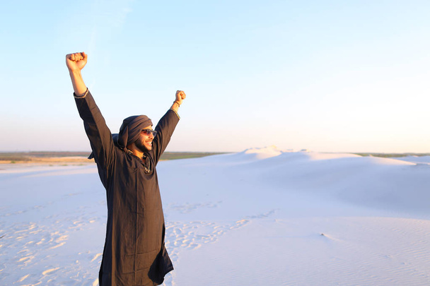 Felice collega arabo, cammina attraverso il deserto, sorride e gode li
 - Foto, immagini