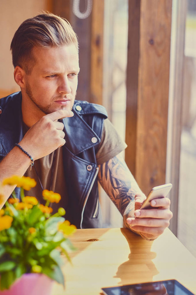 Homme utilisant un smartphone dans un café
. - Photo, image
