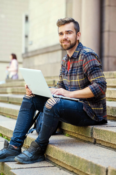 Casual bearded male using a laptop. - Фото, зображення