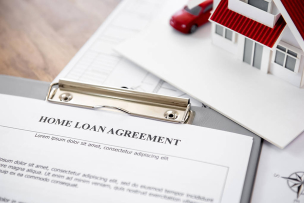 Home loan agreement with house model on the table - Foto, Imagen