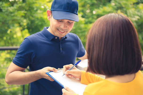 Smiling delivery man deliver parcel box to a woman - Photo, Image