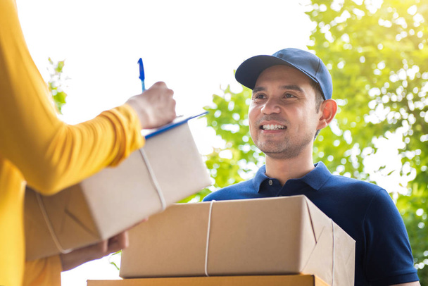 Smiling delivery man deliver parcel boxes to a woman - Photo, Image