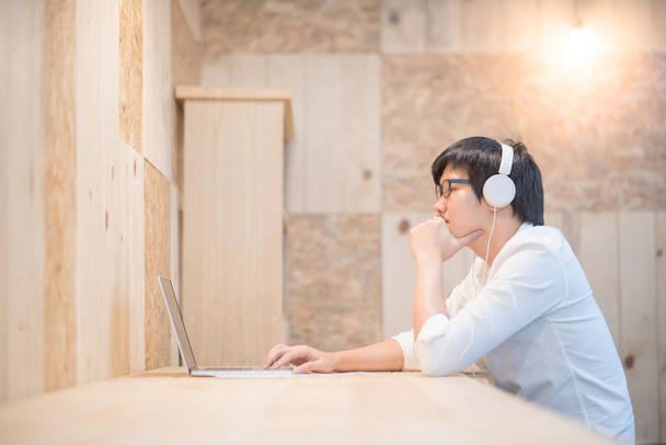 Młody człowiek Asian ze słuchawkami, słuchanie muzyki - Zdjęcie, obraz