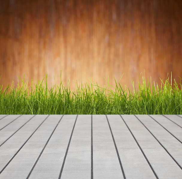 Friss tavaszi fű, fa padló  - Fotó, kép