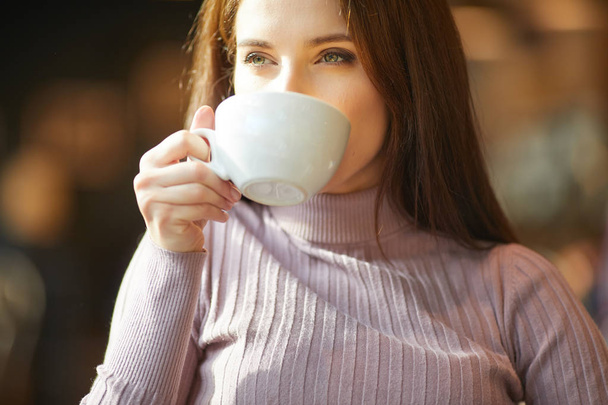 vrouw die koffie drinkt in cafe - Foto, afbeelding
