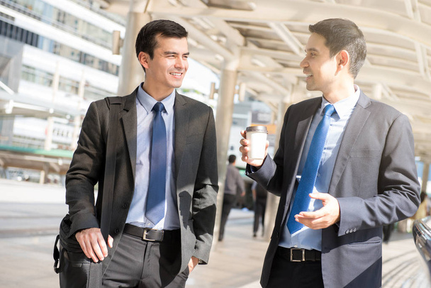 Межрасовые бизнесмены, как коллега, ходить и говорить в
 - Фото, изображение