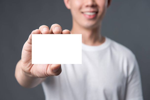 Jeune homme portant une carte d'affaires blanche - Photo, image