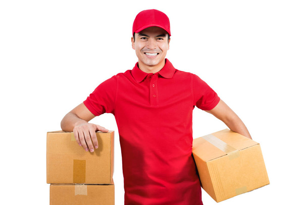 Smiling handsome delivery man in red uniform  - Foto, afbeelding