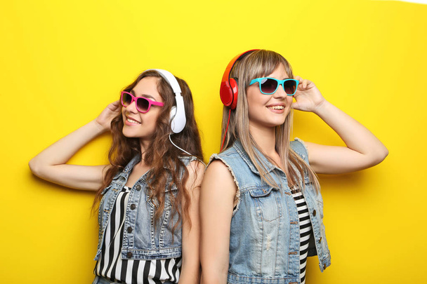 Portrait of two young woman with sunglasses and headphones - Photo, Image