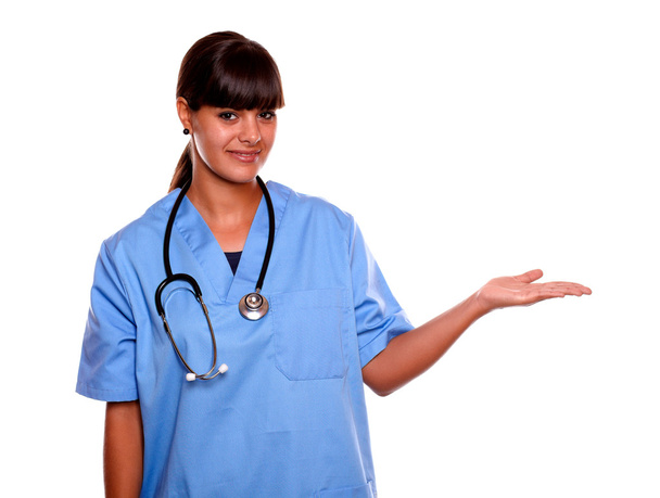 Young nurse holding out her palm showing copyspace - Foto, imagen